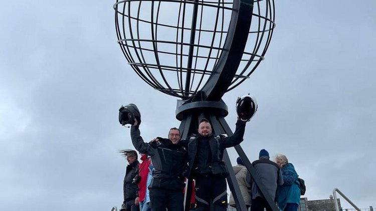 Tobias und Grischa n Motorradkleidung vor dem Globus-Denkmal am Nordkapordkap