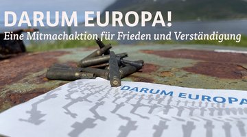 Alte Patronenhülsen liegen auf einer Postkarte mit der Aufschrift „Darum Europa“ und Reihen von stilisierten, leicht verschwommenen, Grabkreuzen 