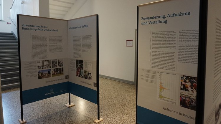 Zwei Module der Ausstellung „geflohen – vertrieben – angekommen?! – Aspekte der Gewaltmigration im 20. und 21. Jahrhundert“. Die Banner sind über Metallgestelle gespannt.