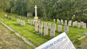 Eine Ecke der Postkarte „Darum Europa“. Im Hintergrund eine Kriegsgräberstätte